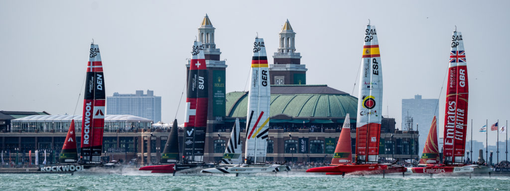 ROCKWOOL Denmark SailGP Team helmed by Nicolai Sehested leads Switzerland SailGP Team, Germany SailGP Team, Spain SailGP Team and Emirates Great Britain SailGP Team past Navy Pier on Race Day 1 of the Rolex United States Sail Grand Prix | Chicago at Navy Pier, Season 4, in Chicago, Illinois, USA. 16th June 2023. Photo: Bob Martin for SailGP. Handout image supplied by SailGP